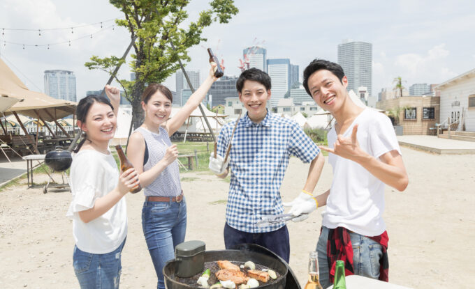 屋外でバーベキューをする男女4人組