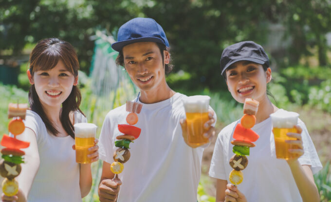 BBQ串とビールを楽しむ3人