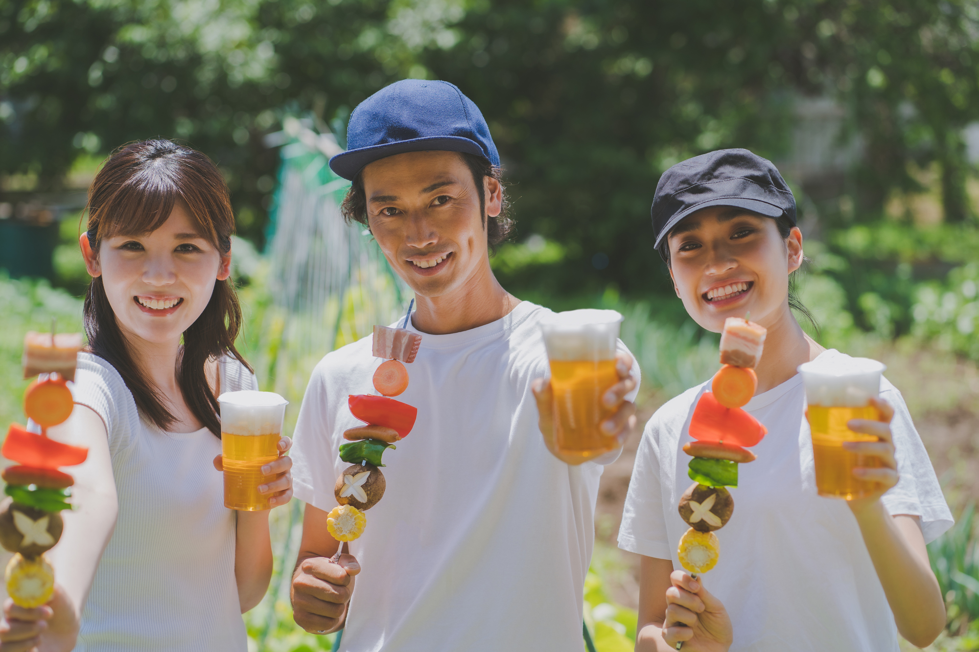 BBQ串とビールを楽しむ3人