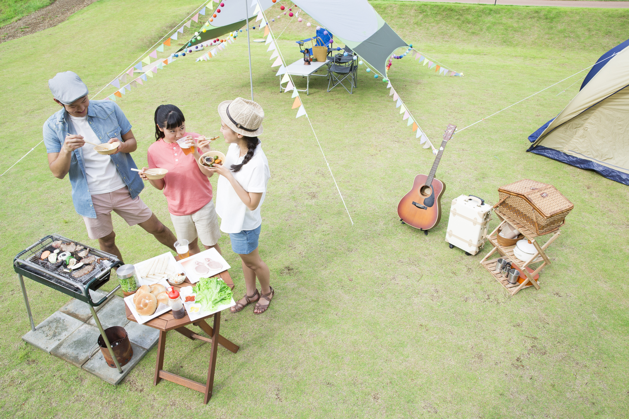 屋外でバーベキューをする三人組