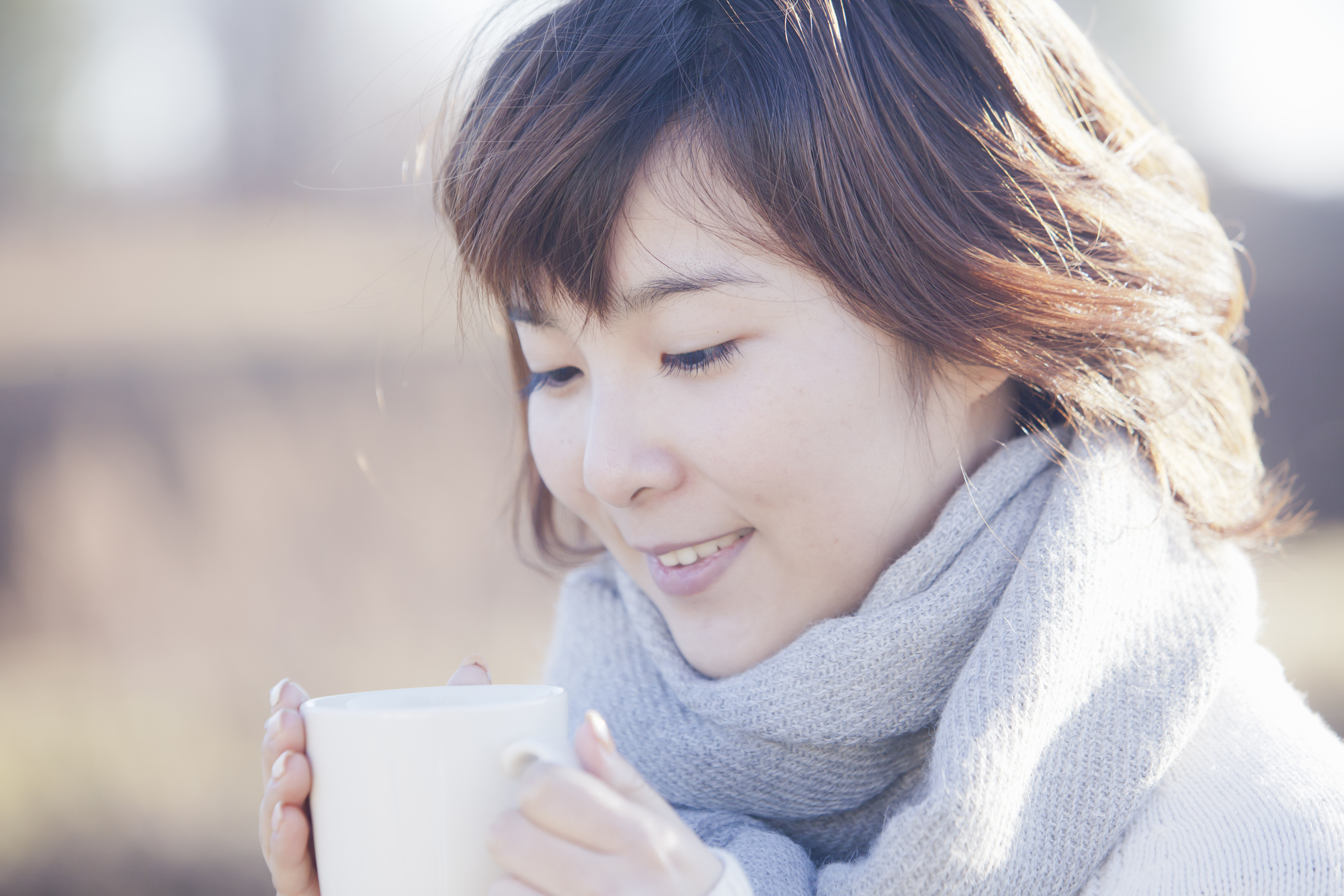 寒い中ホットドリンクを飲む女性