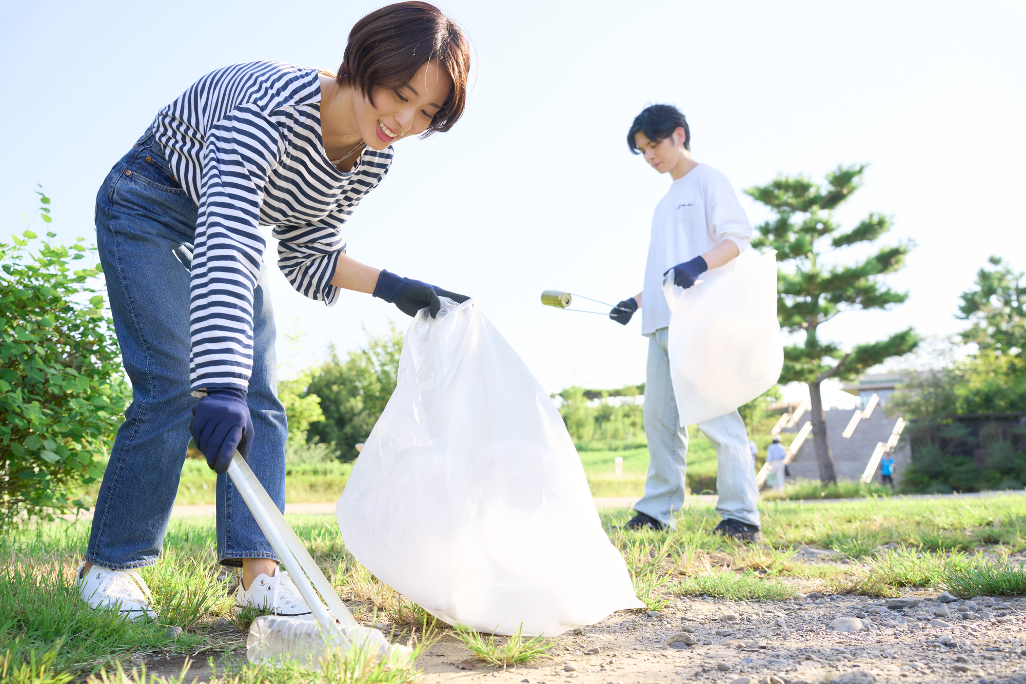 ゴミ拾いをする若い男女