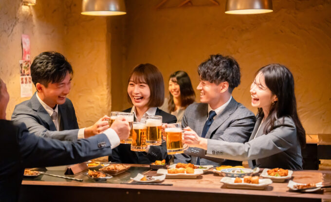 居酒屋で若手社員同士で乾杯